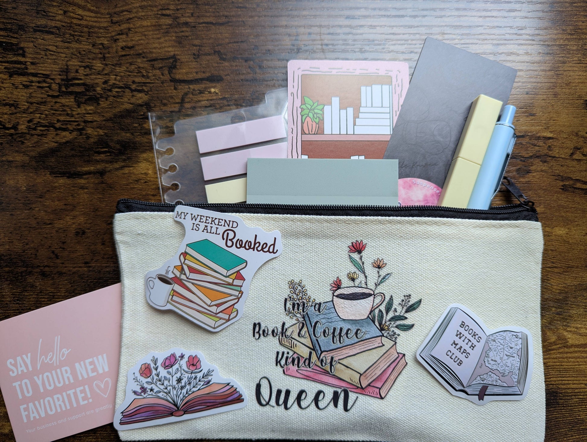 Pouch with book-themed designs and text on a wooden surface