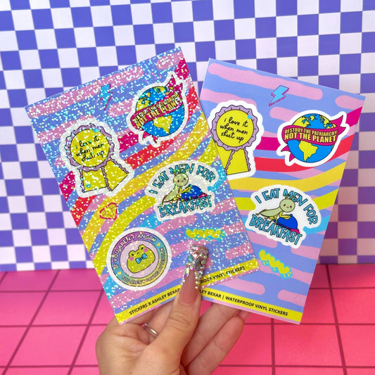 Colorful sticker sheets held by a hand on a checkered background