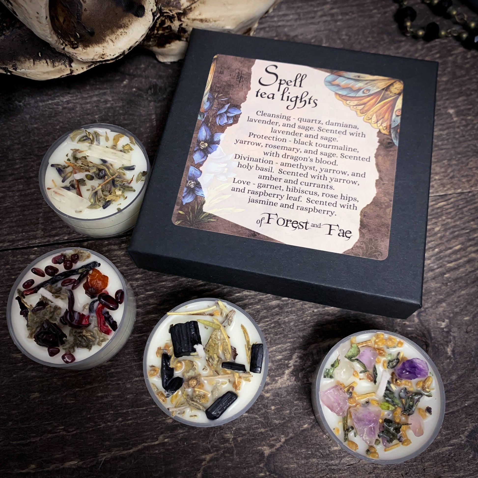 Spell tea lights with decorative packaging on a dark surface