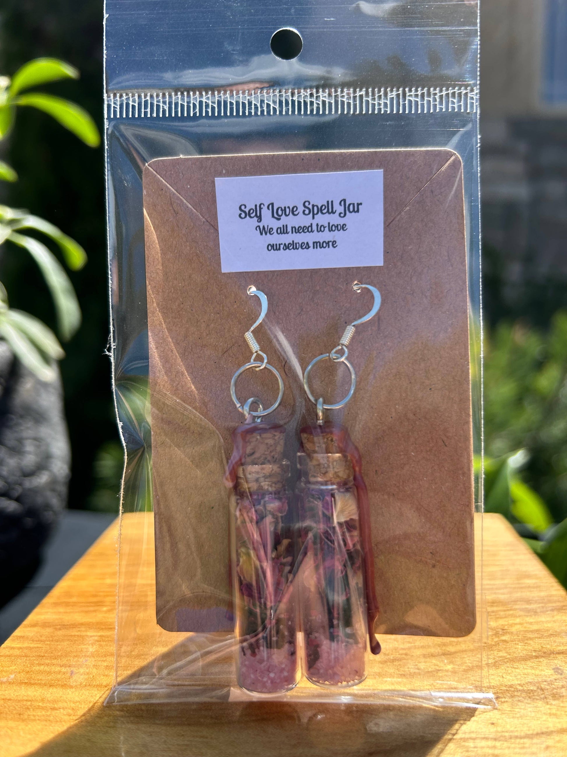 Earrings in a clear packaging with a label on a wooden surface