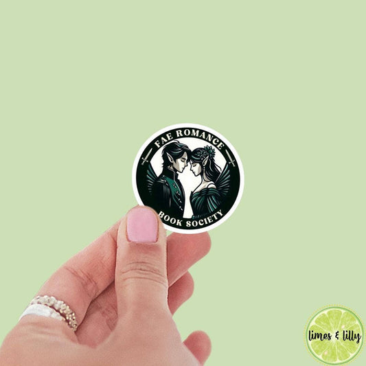 Hand holding a sticker with 'FAE Romance Book Society' design on a light green background