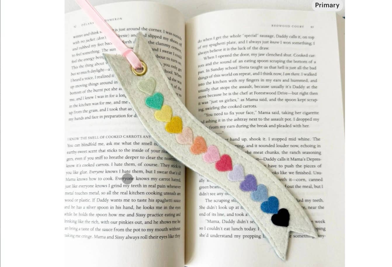 Ribbon-shaped bookmark with colorful heart decorations on an open book