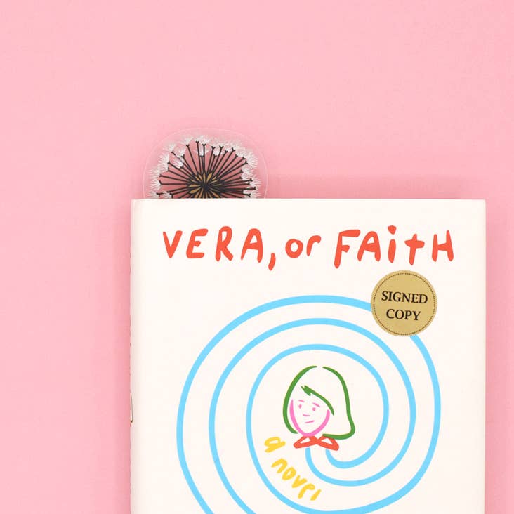 Book titled 'Vera, or Faith' with a decorative item on a pink background