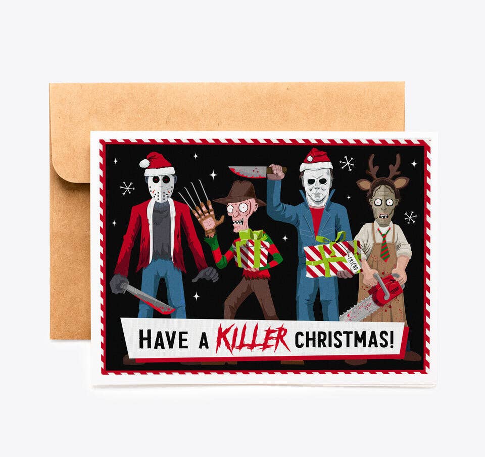 A horror-themed Christmas greeting card with a kraft paper envelope behind it, featuring illustrated characters in holiday costumes holding weapons on a black background with the text 'HAVE A KILLER CHRISTMAS!'.