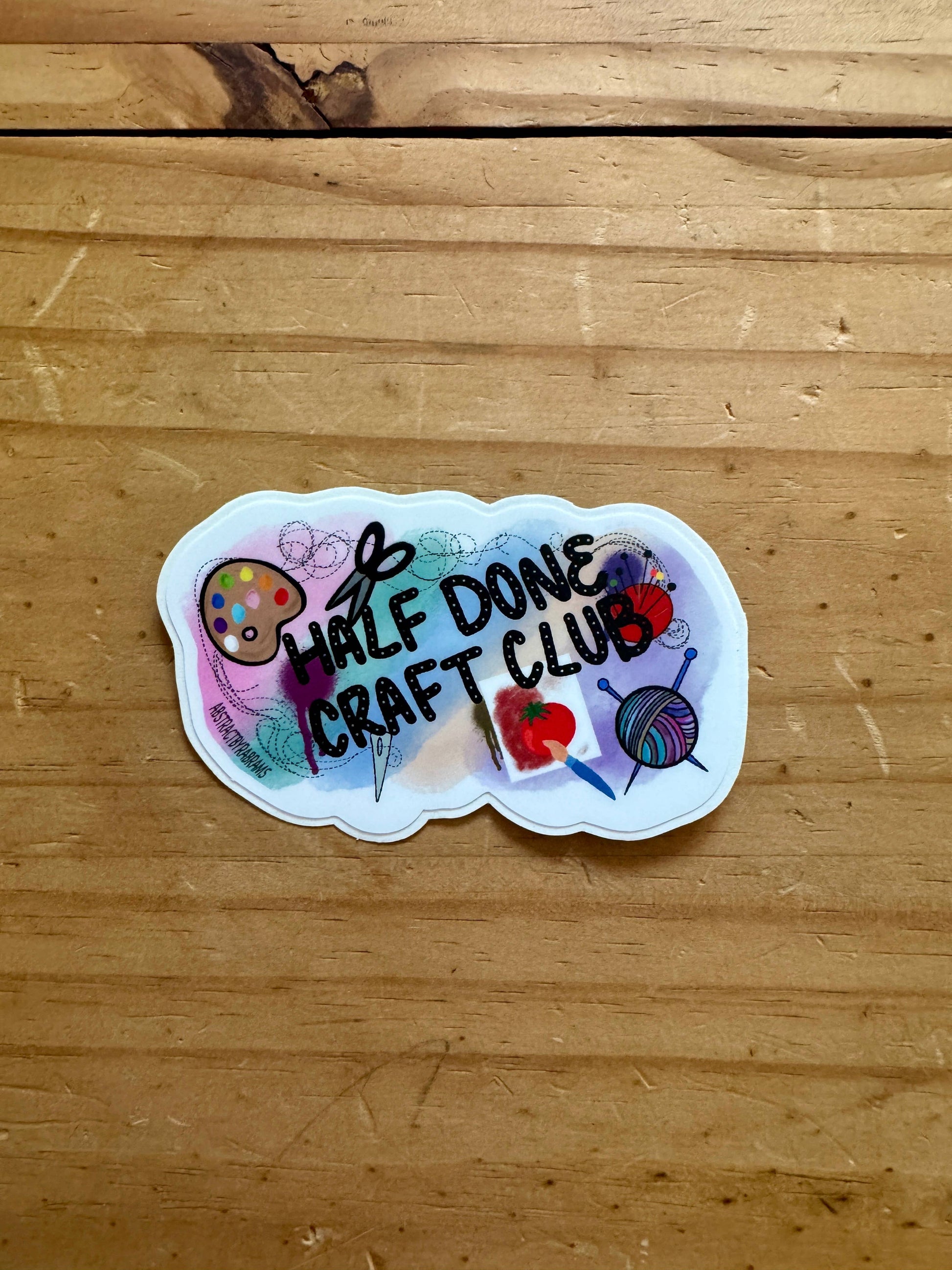 Sticker with 'Half Done Craft Club' text on a wooden surface