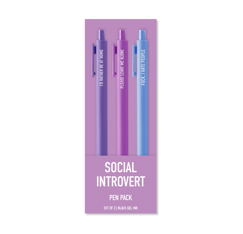 A 3-pack of gel pens in a lavender card sleeve. The pens are purple and blue, each printed with a humorous social introvert quote like 'I'D rather be a FLOKE', 'PASSIVE LOVE IS ALIVE', and 'FOCK.