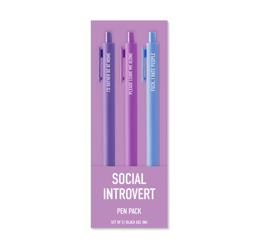 A 3-pack of gel pens in a lavender card sleeve. The pens are purple and blue, each printed with a humorous social introvert quote like 'I'D rather be a FLOKE', 'PASSIVE LOVE IS ALIVE', and 'FOCK.