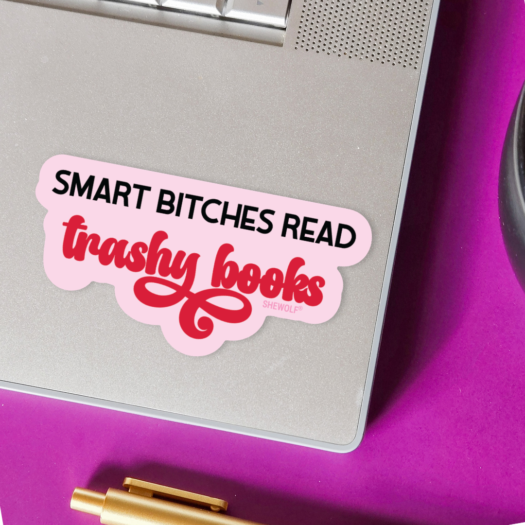 Pink sticker with text on a laptop against a purple background