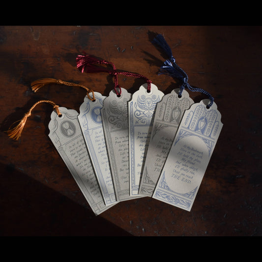Decorative bookmarks with text and designs on a dark surface