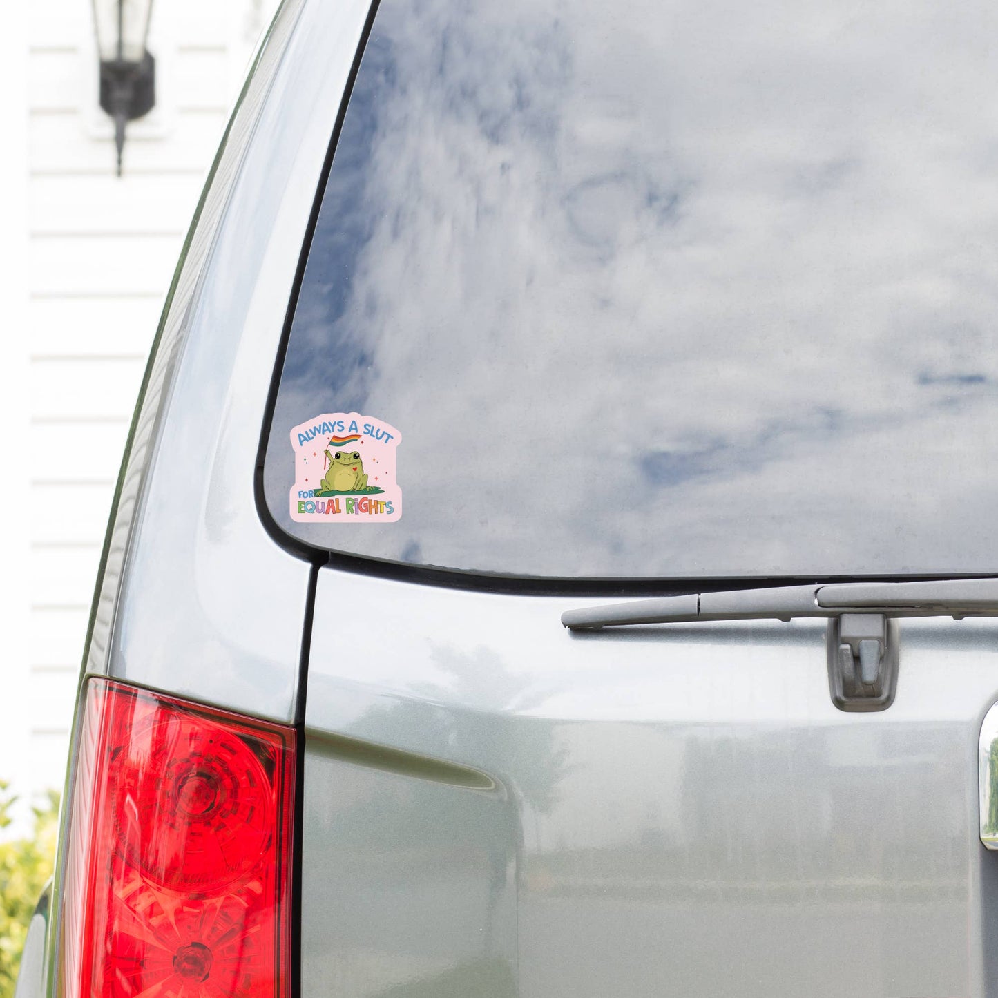 Car with a sticker on the rear window displaying cartoon characters with text 'Support'.