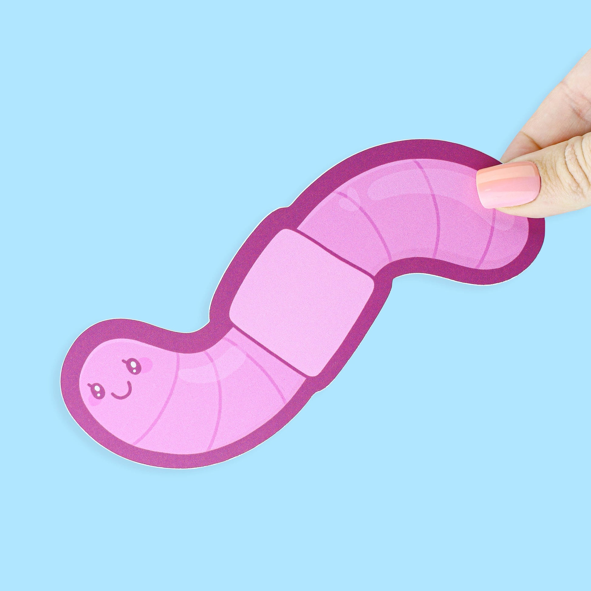 Pink toy worm held by a hand against a light blue background