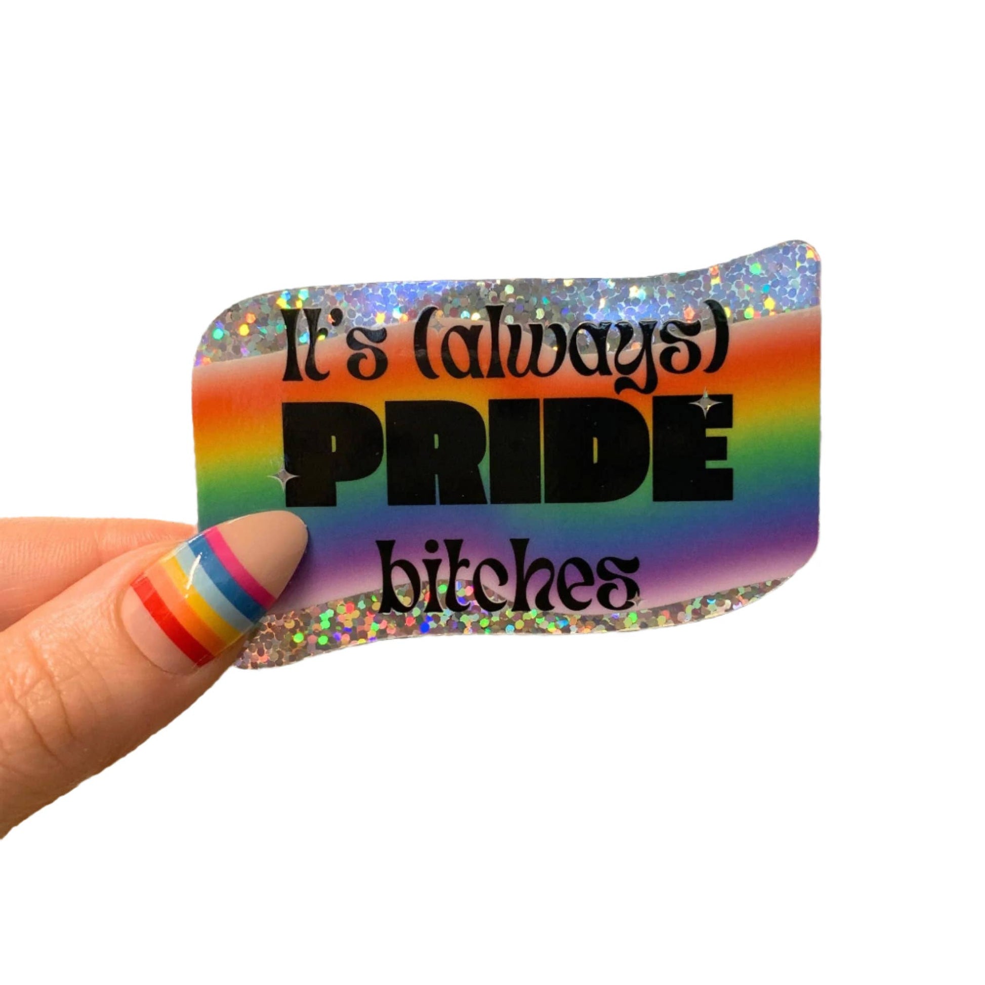 Rainbow-colored card with text 'It's (always) PRIDE bitches' held by a hand with multicolored nails.