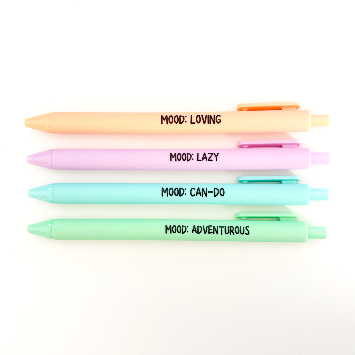 Four pastel gel pens stacked vertically on a white background, each with a different color and printed with a black text label: 'MOOD: LOVING', 'MOOD: LAZY', 'MOOD: CAN-DO', and 'MOOD: ADVENTUROUS'.