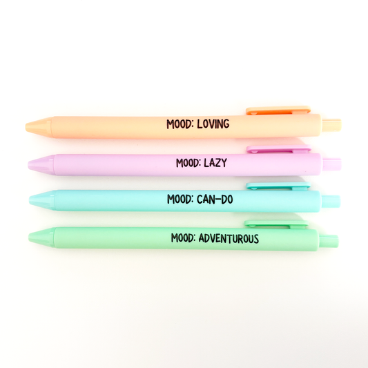Four pastel gel pens stacked vertically on a white background, each with a different color and printed with a black text label: 'MOOD: LOVING', 'MOOD: LAZY', 'MOOD: CAN-DO', and 'MOOD: ADVENTUROUS'.