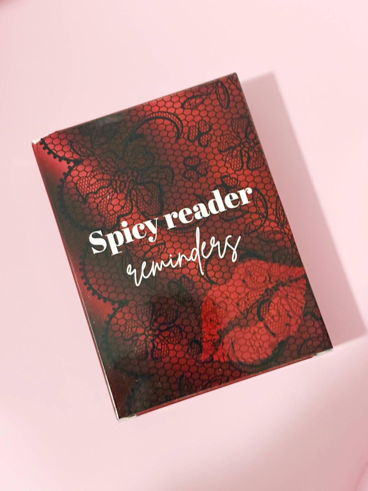 Book titled 'Spicy reader reminders' with red and black design on a pink background