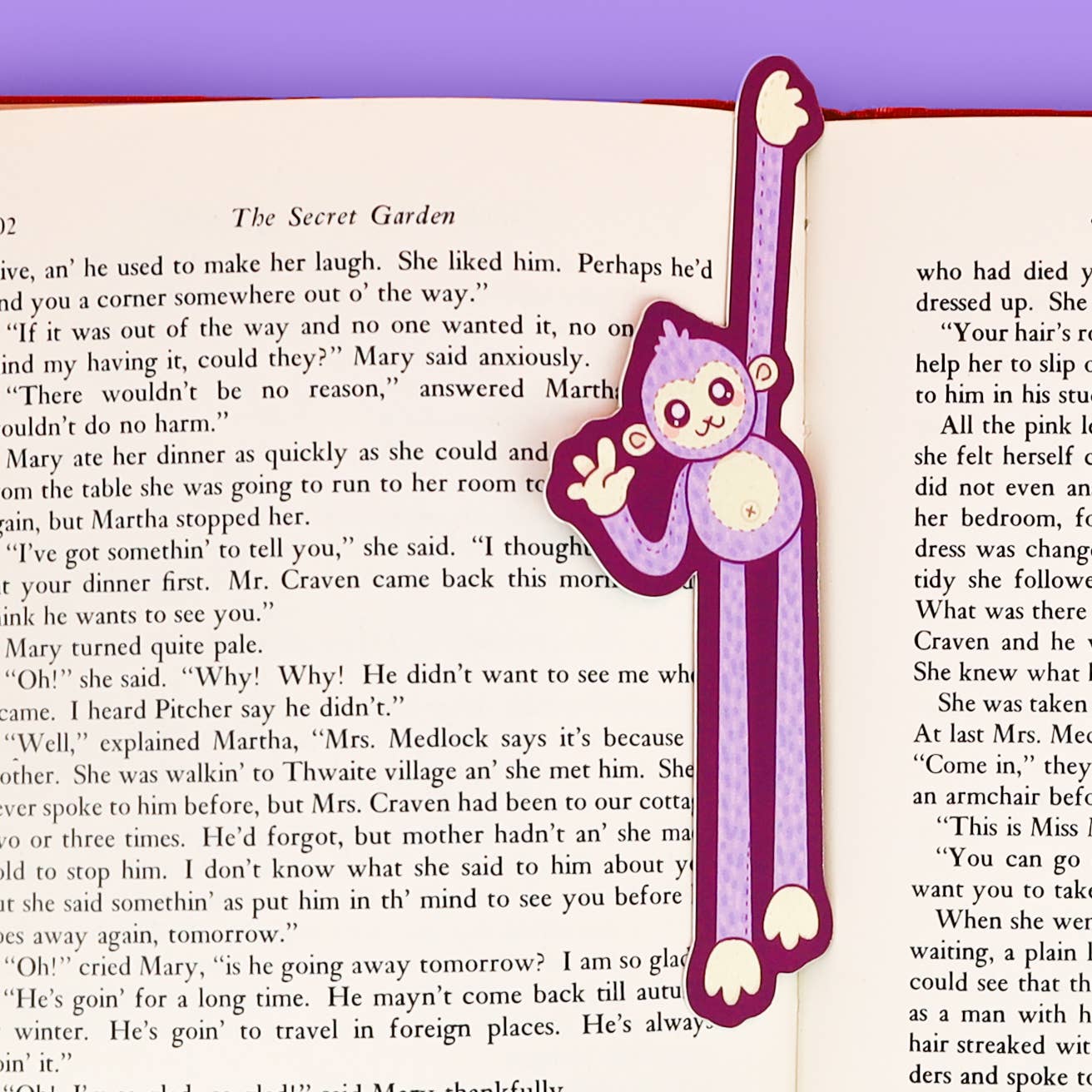 Bookmark with a purple monkey design on an open book