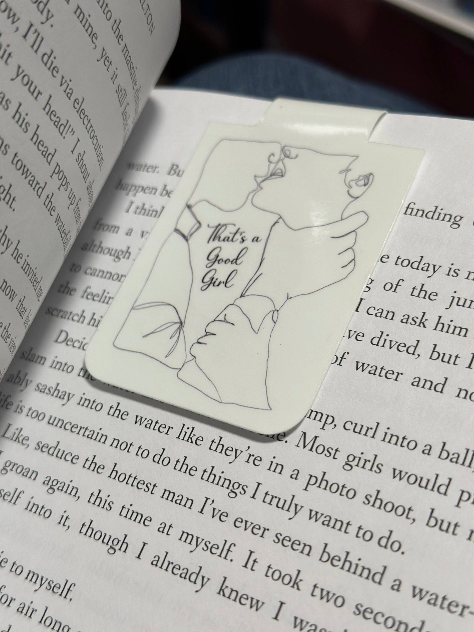 Book with a bookmark featuring a drawing of a woman and text on a page.