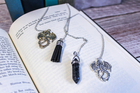 Two necklaces with dragon pendants on an open book