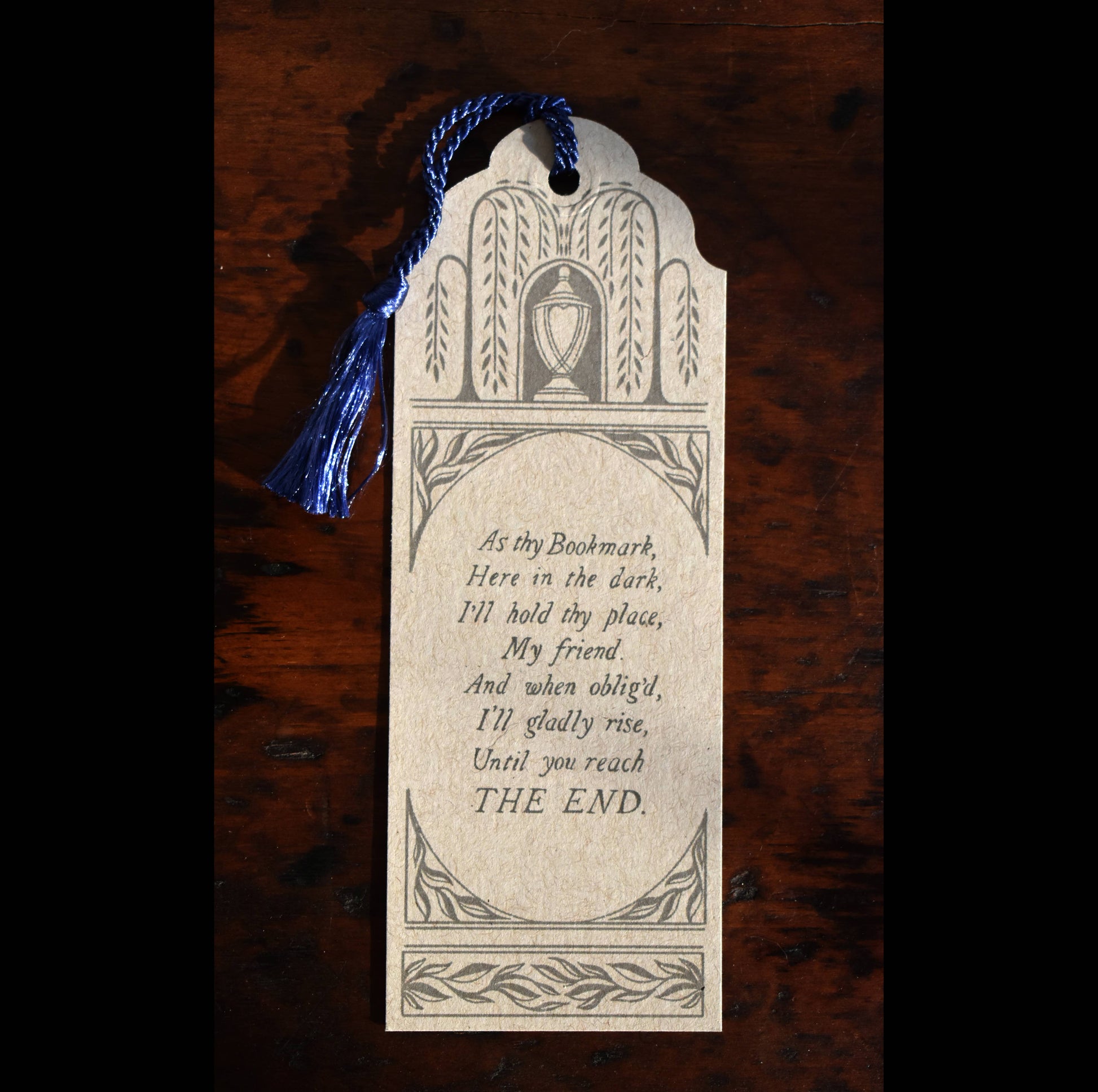 Decorative bookmark with text on a wooden surface