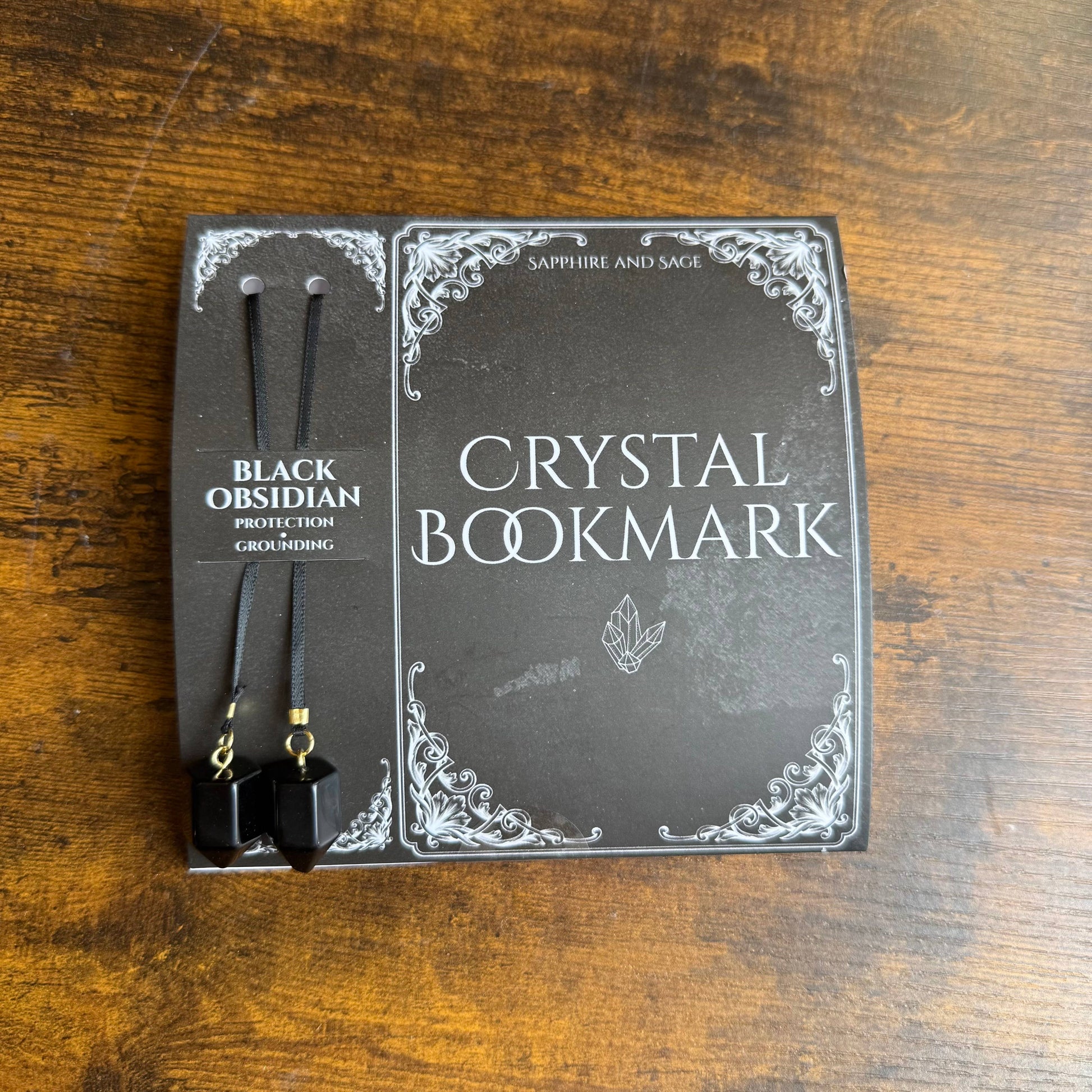 Crystal bookmark packaging on a wooden surface