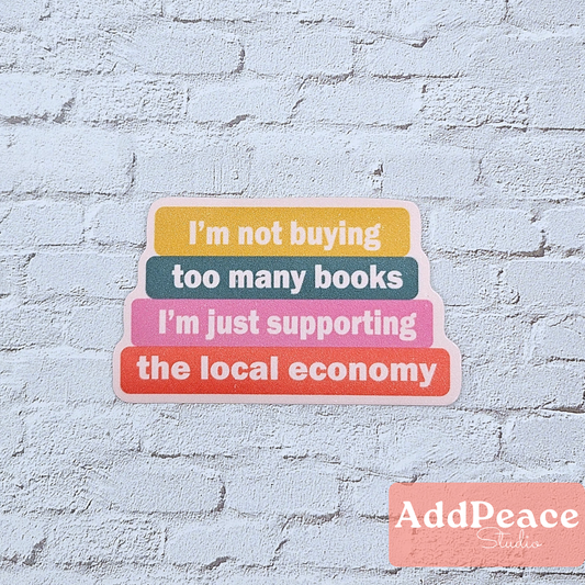 Stack of colorful stickers with humorous text on a light blue brick wall background, featuring the brand 'AddPeace Studio'.