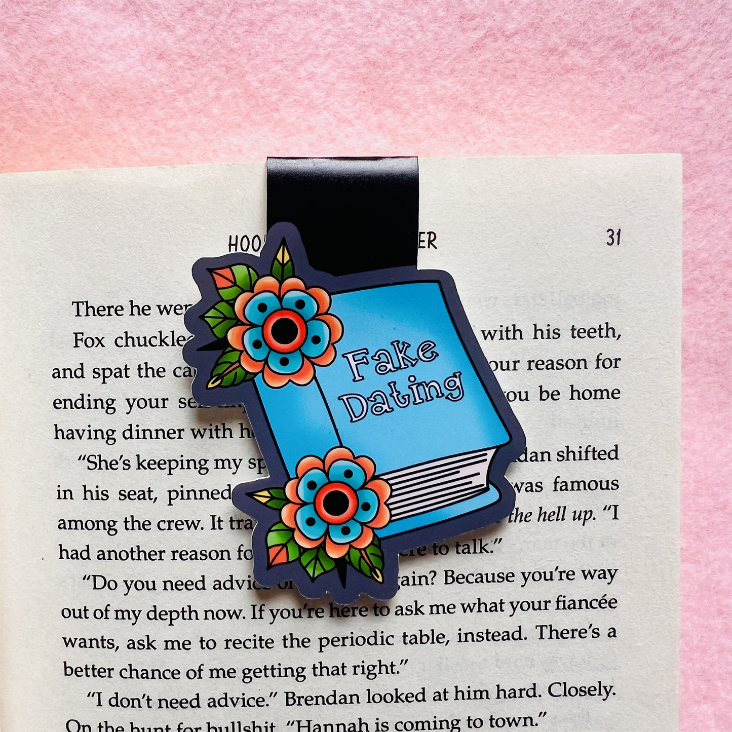 Floral bookmark with 'Fake Dating' text on a book page