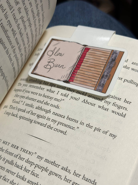 Book with a bookmark featuring an illustration of a book titled 'Slow Burn'.
