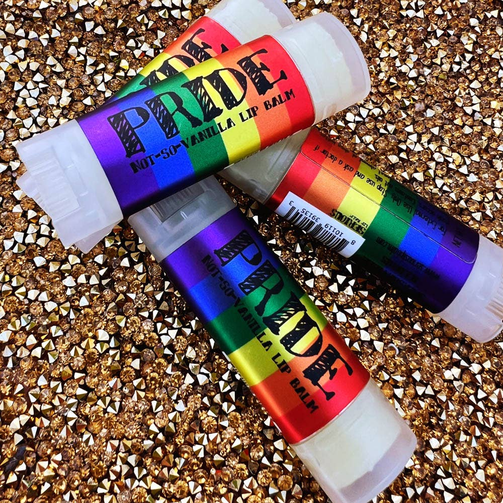 Two Pride-themed lip balms on a glittery surface