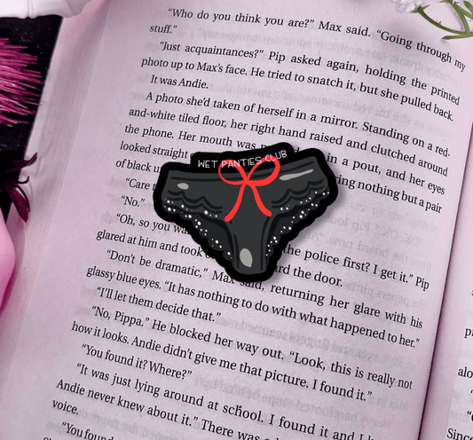 Black phone case with a red bow on an open book