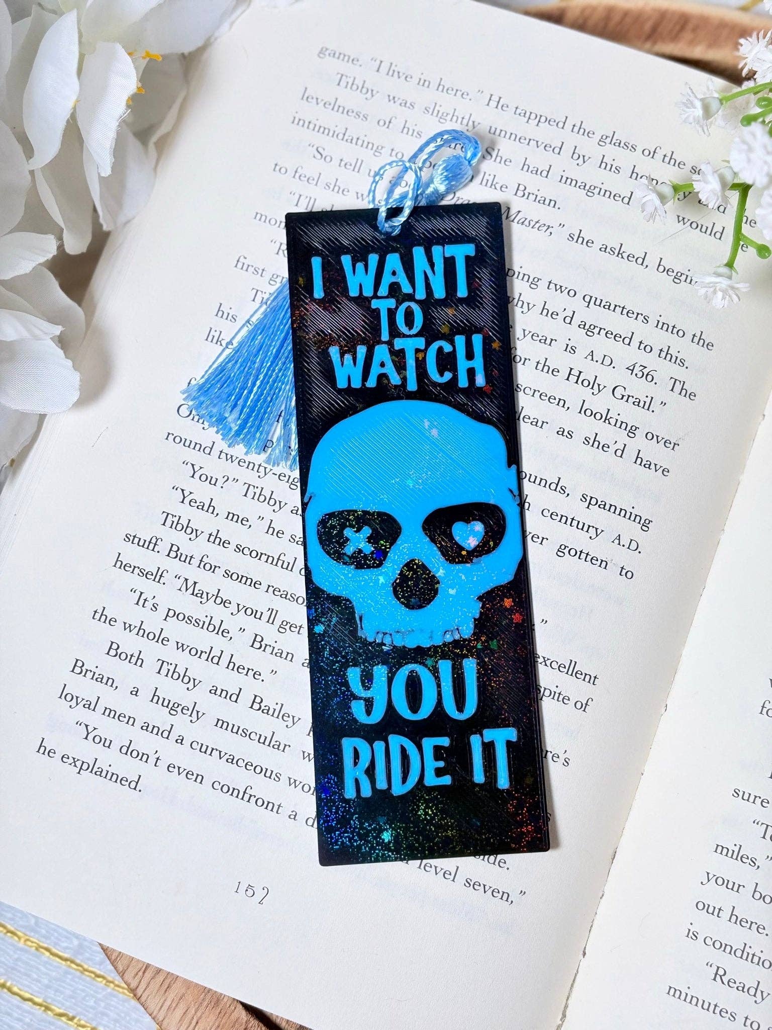 Bookmark with skull design and text on an open book