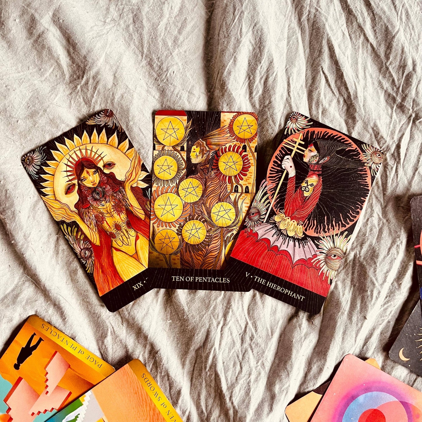 Colorful tarot cards on a textured fabric surface