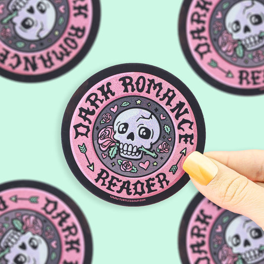 Sticker with 'Dark Romance Reader' design held by a hand on a light green background