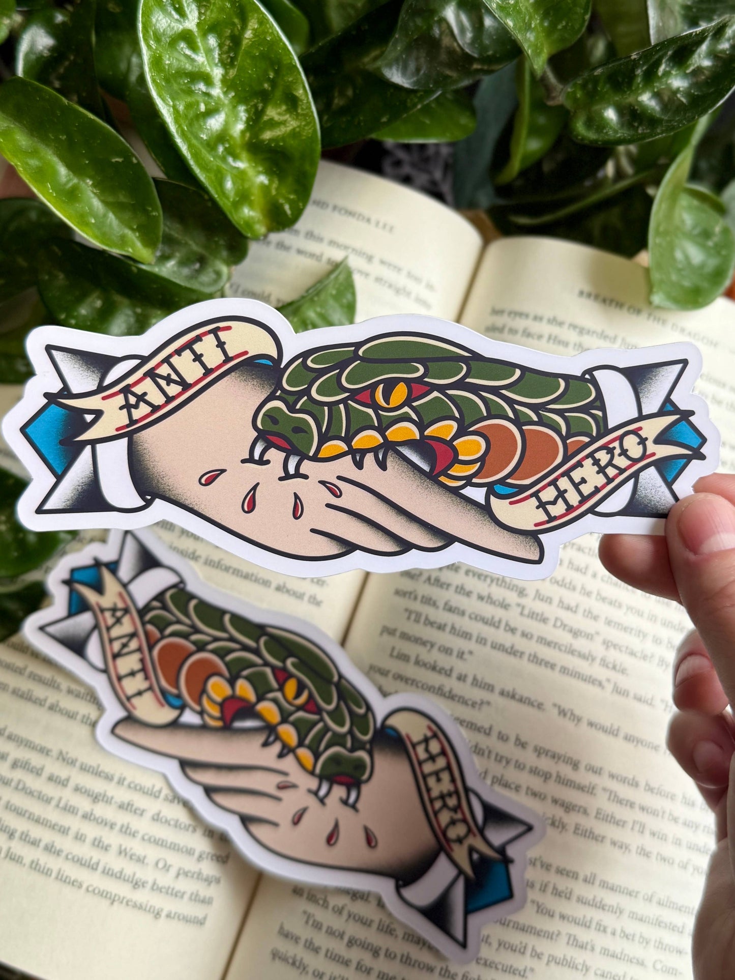 Colorful hand-drawn style stickers of a hand holding a leaf with text on a book page.