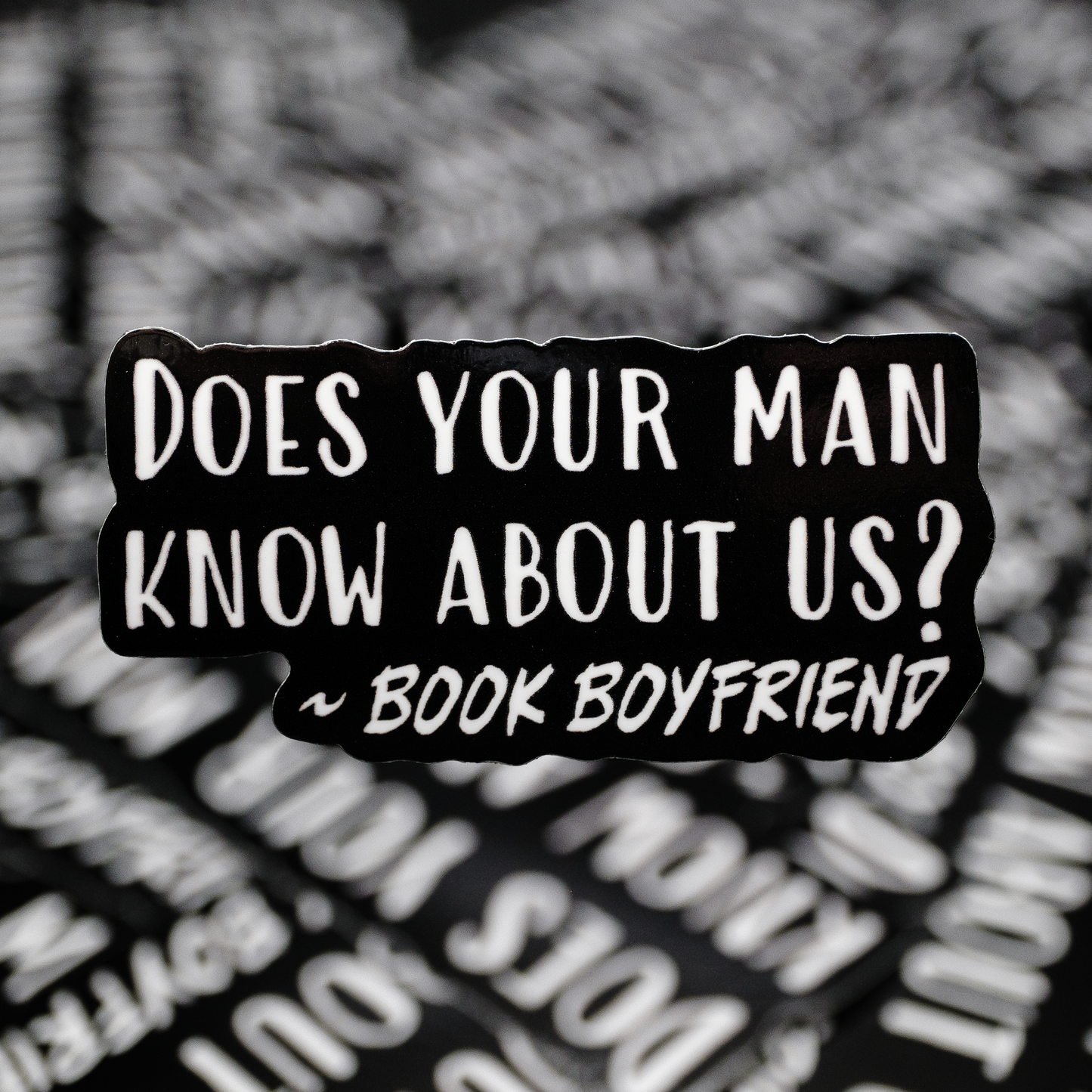 Black and white text sticker with a question about being a 'book boyfriend' on a blurred background.
