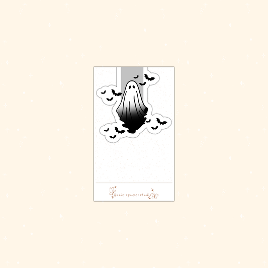 A Halloween-themed magnetic bookmark featuring a black and white dripping ghost surrounded by bats, presented on a white backing card with a small brand logo at the bottom.