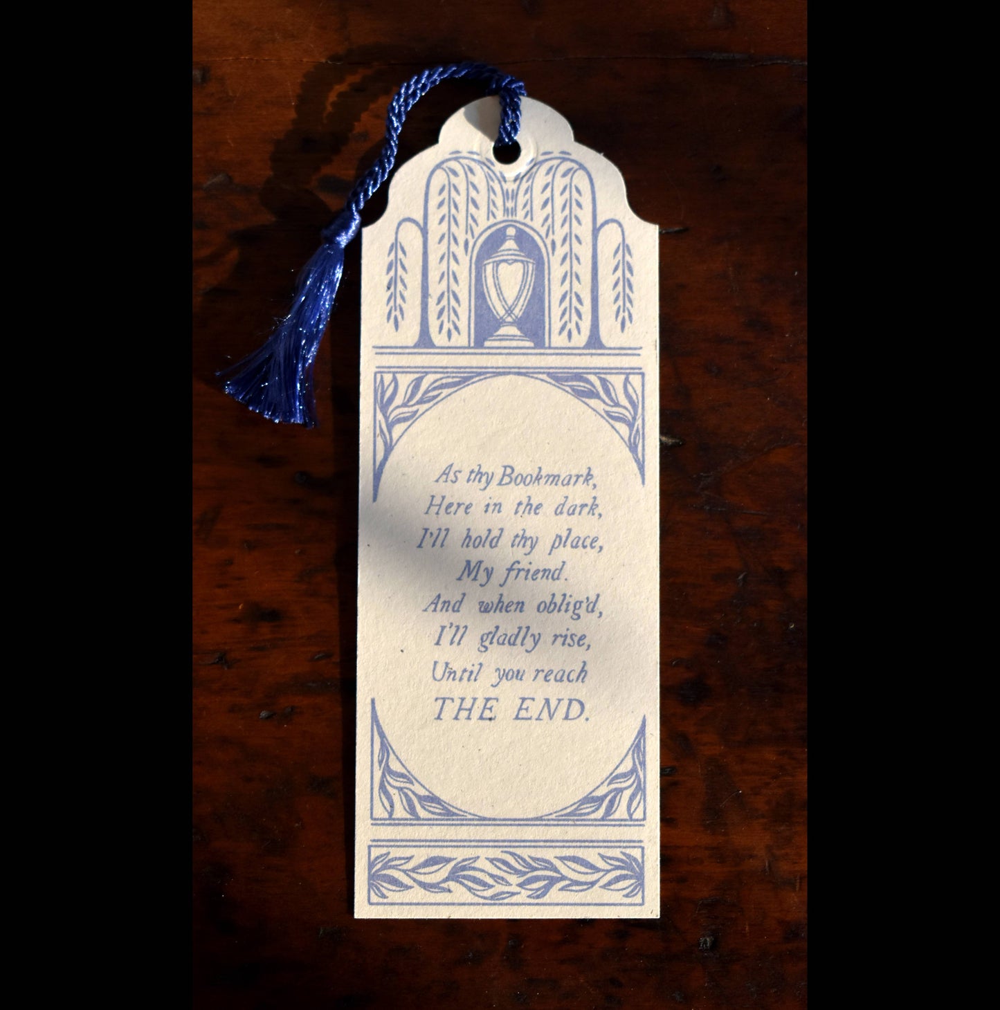 Bookmark with decorative design and text on a wooden surface