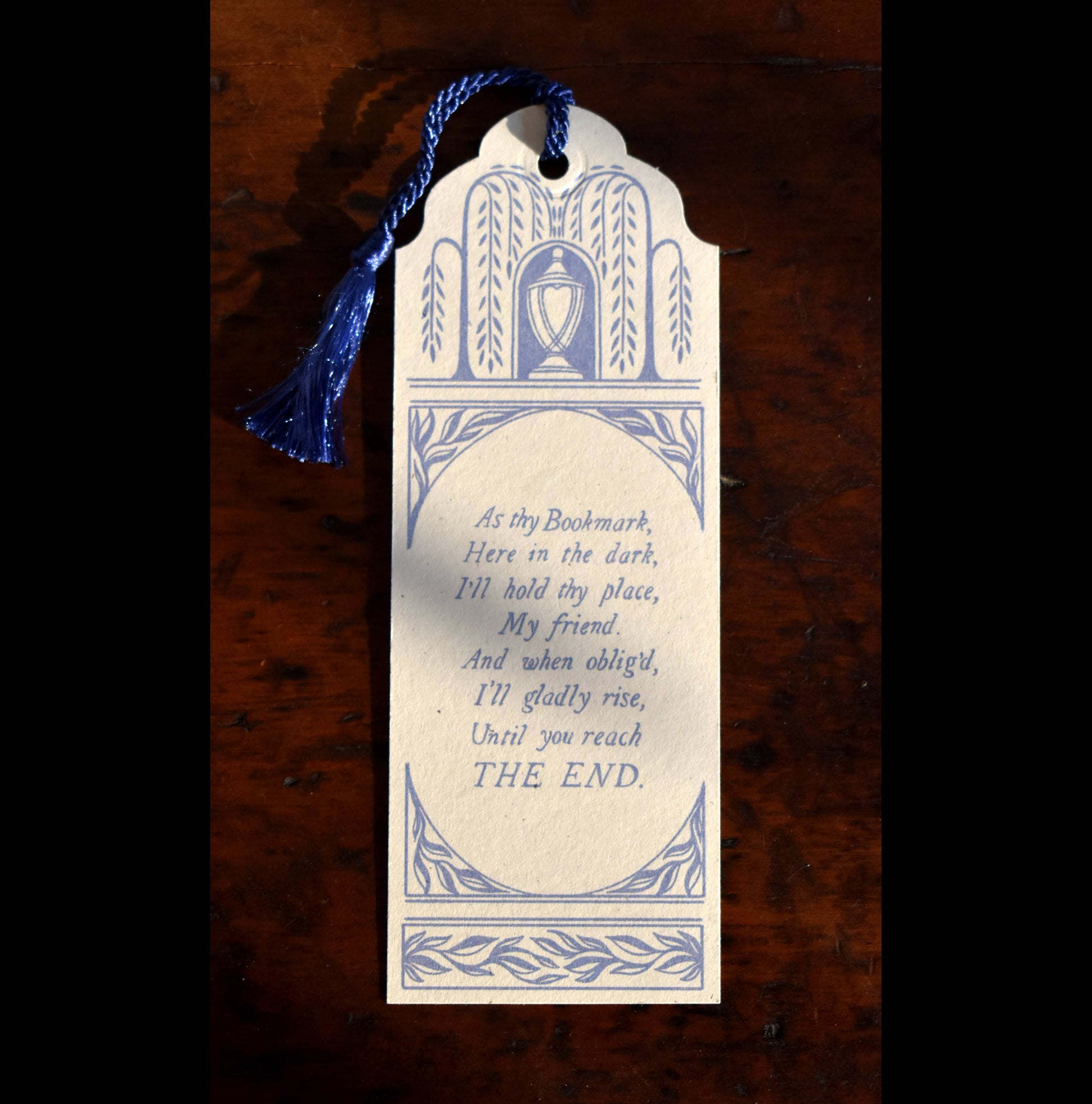 Bookmark with decorative design and text on a wooden surface