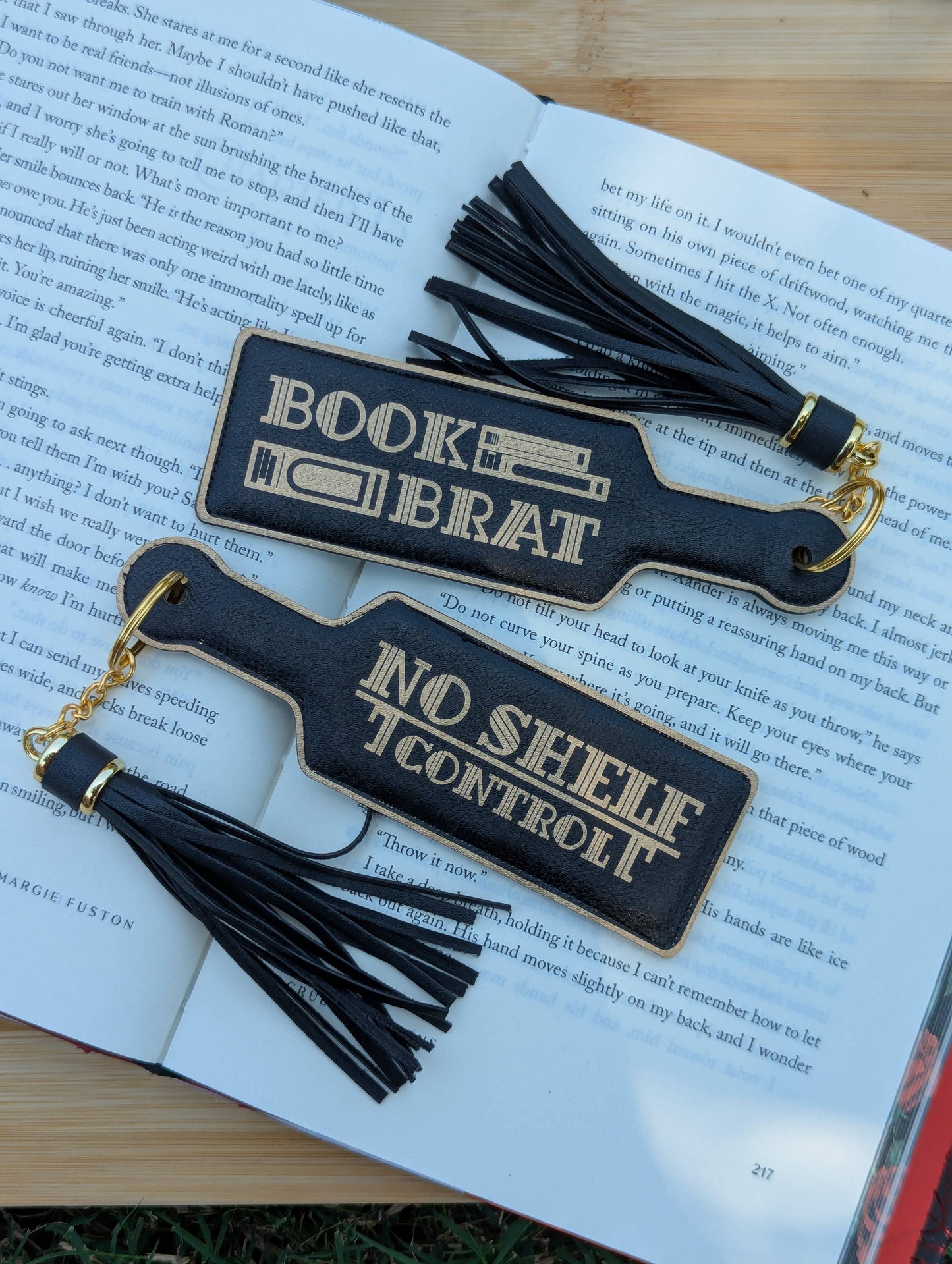 Two black bookmarks with tassels on an open book