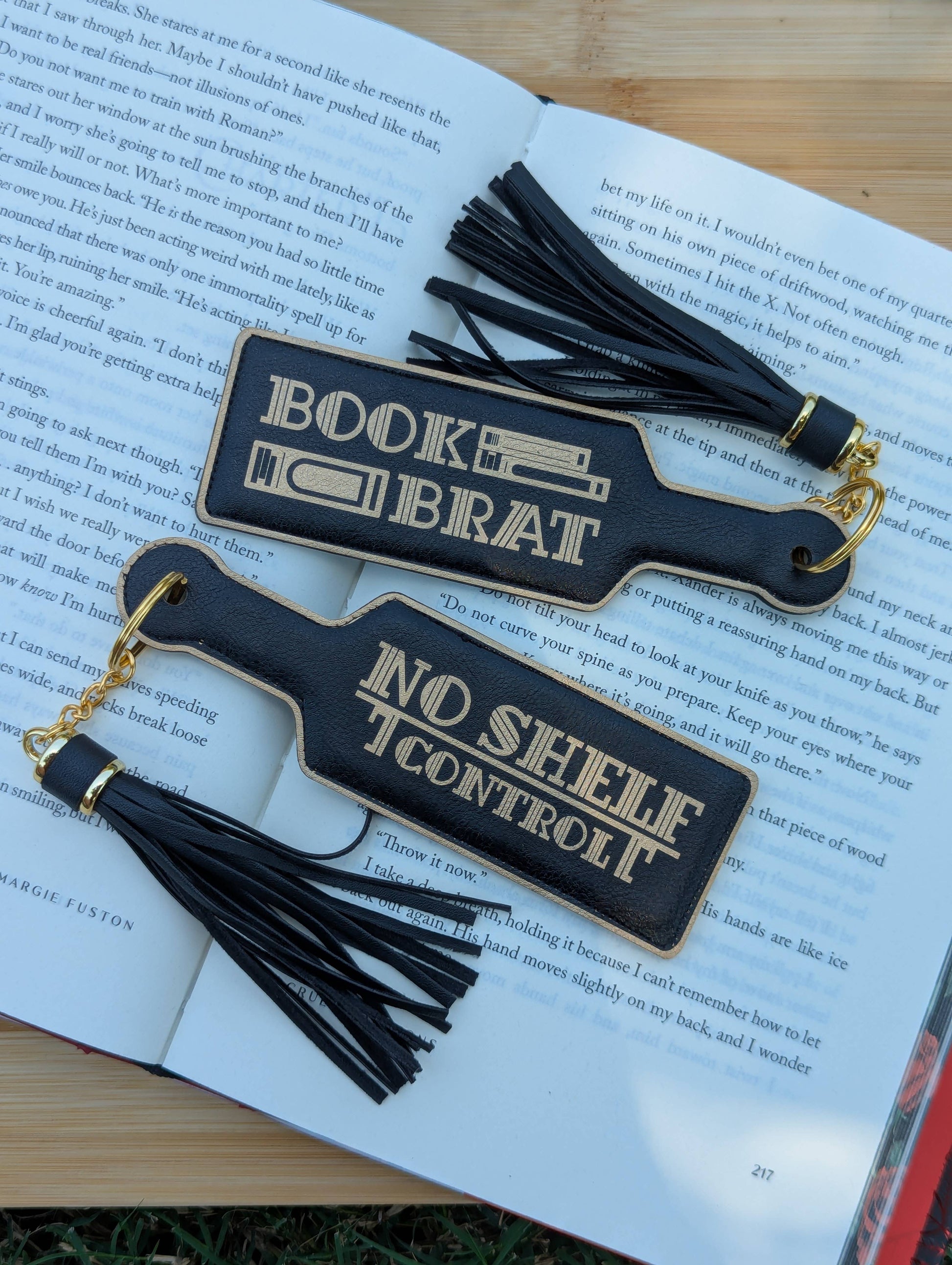 Two black bookmarks with tassels on an open book