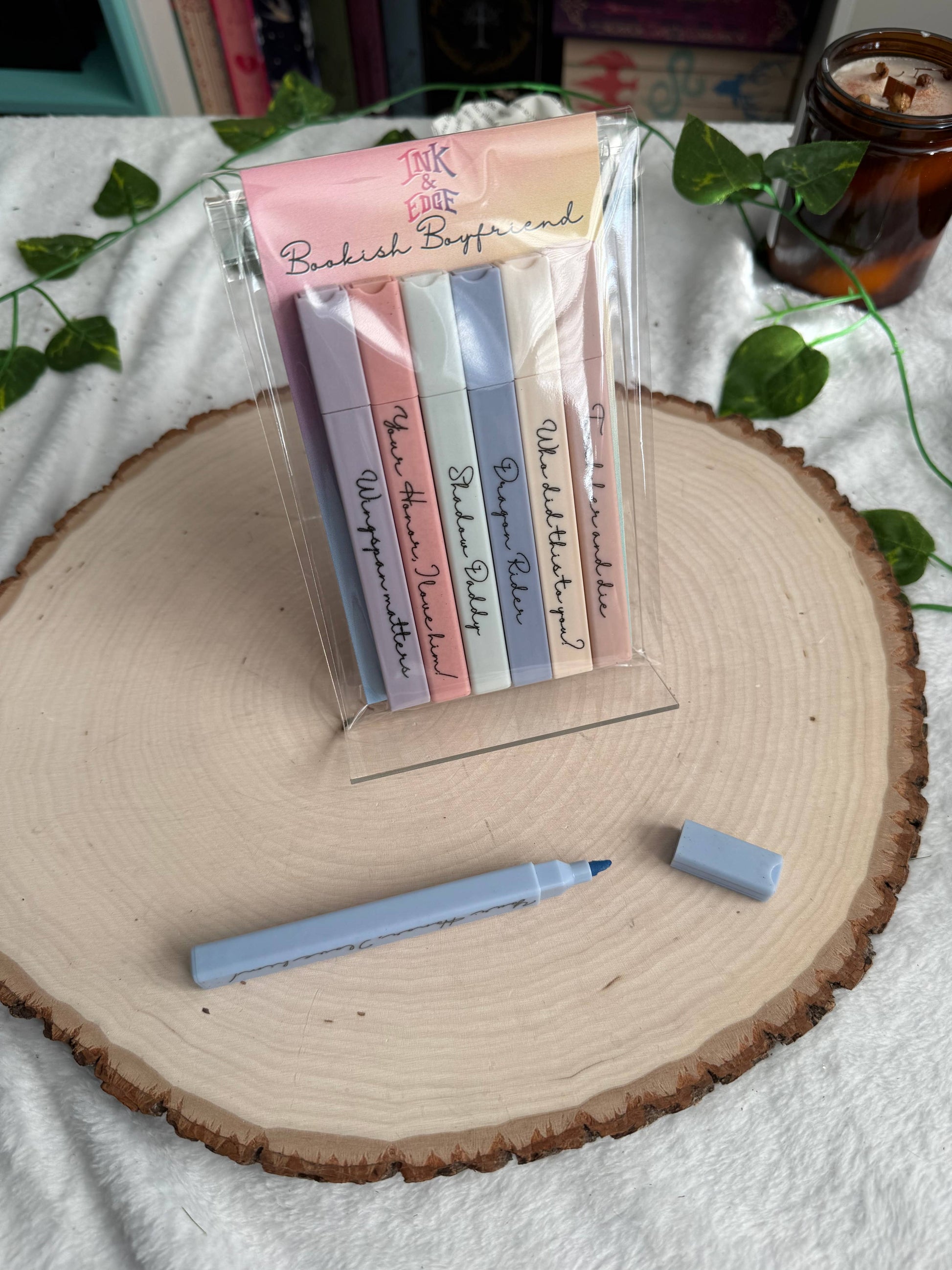 Packaged colorful bookmarks with a pen on a wooden surface