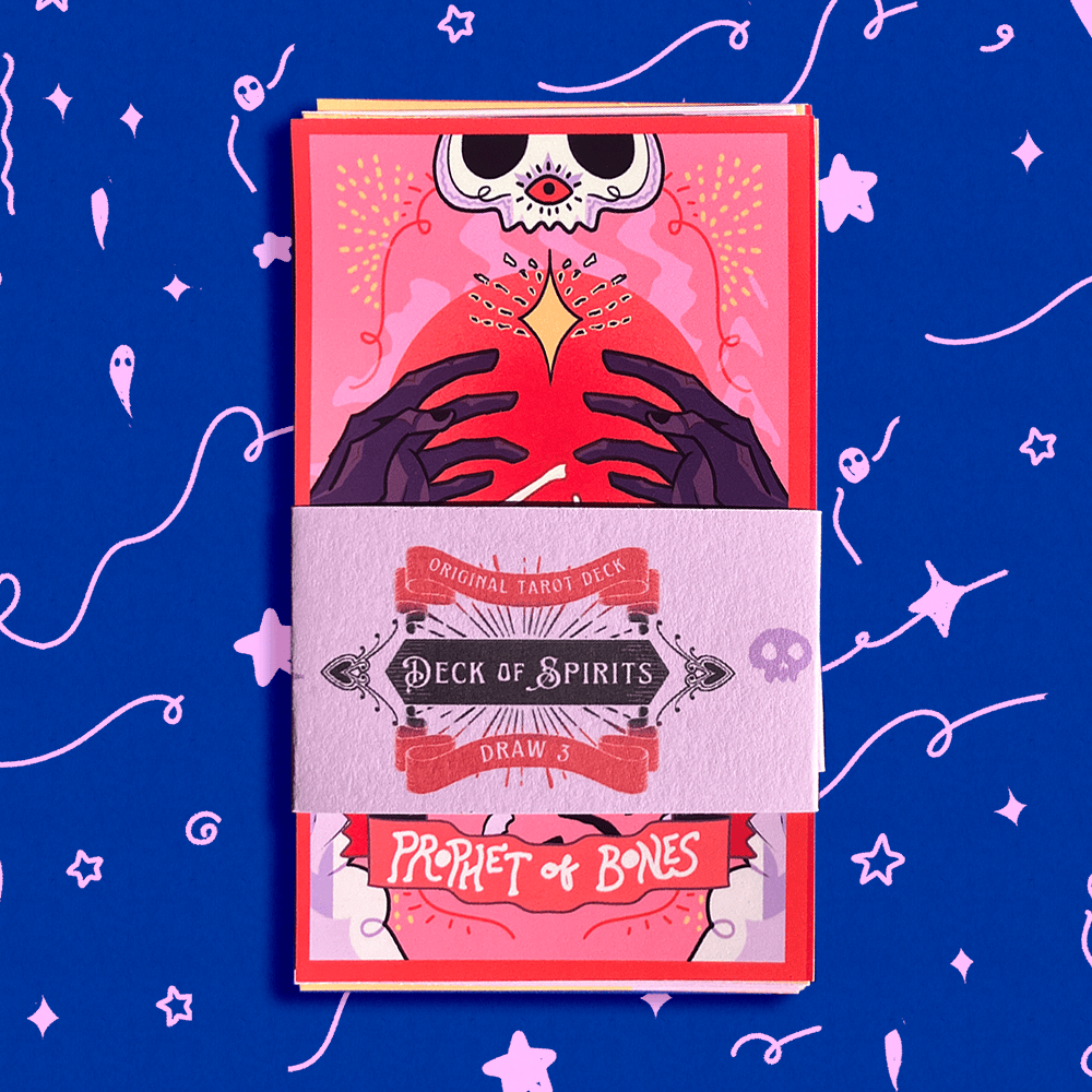A boxed tarot deck wrapped in a paper sleeve labeled 'Deck of Spirits Draw 4' and 'Prophet of Bones,' shown against a bright blue background with pink doodled stars and abstract line art.