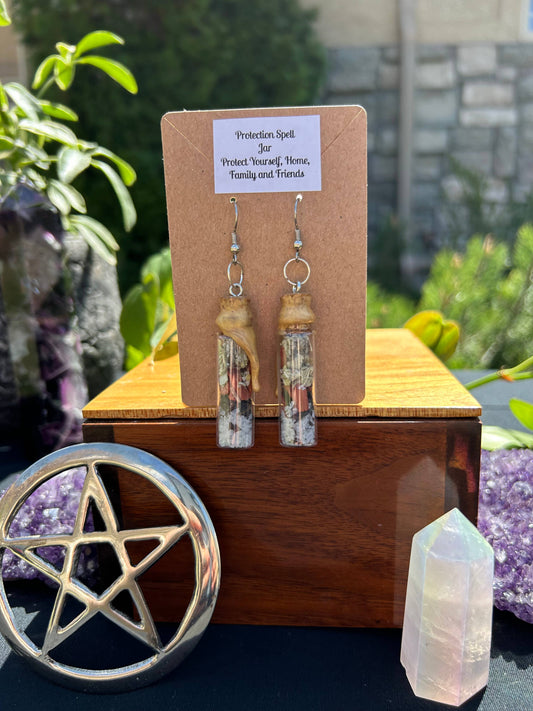 Earrings on a card with a pentacle symbol and crystals in the background