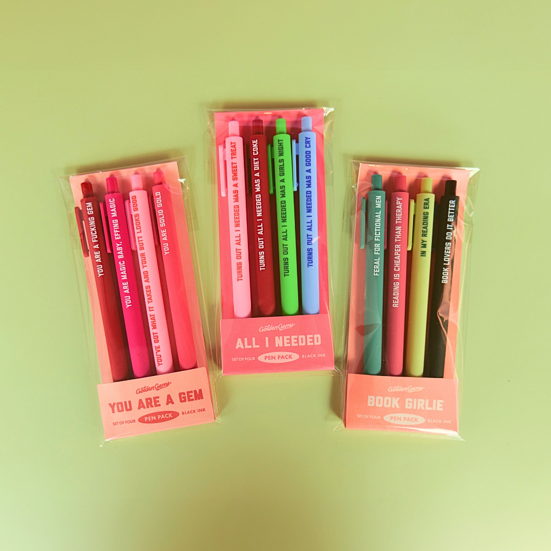 Three packages of colorful pens on a green background