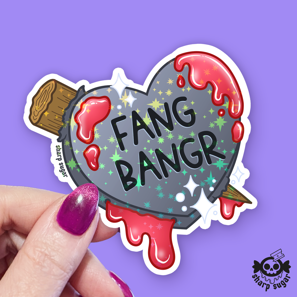 Sticker with 'Fang Bangr' text held by a hand on a purple background