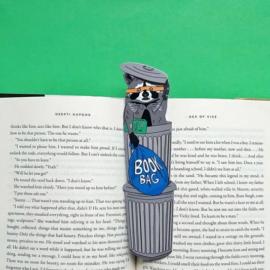 Bookmark shaped like a raccoon in a trash can with a 'Book Bag' label on an open book.