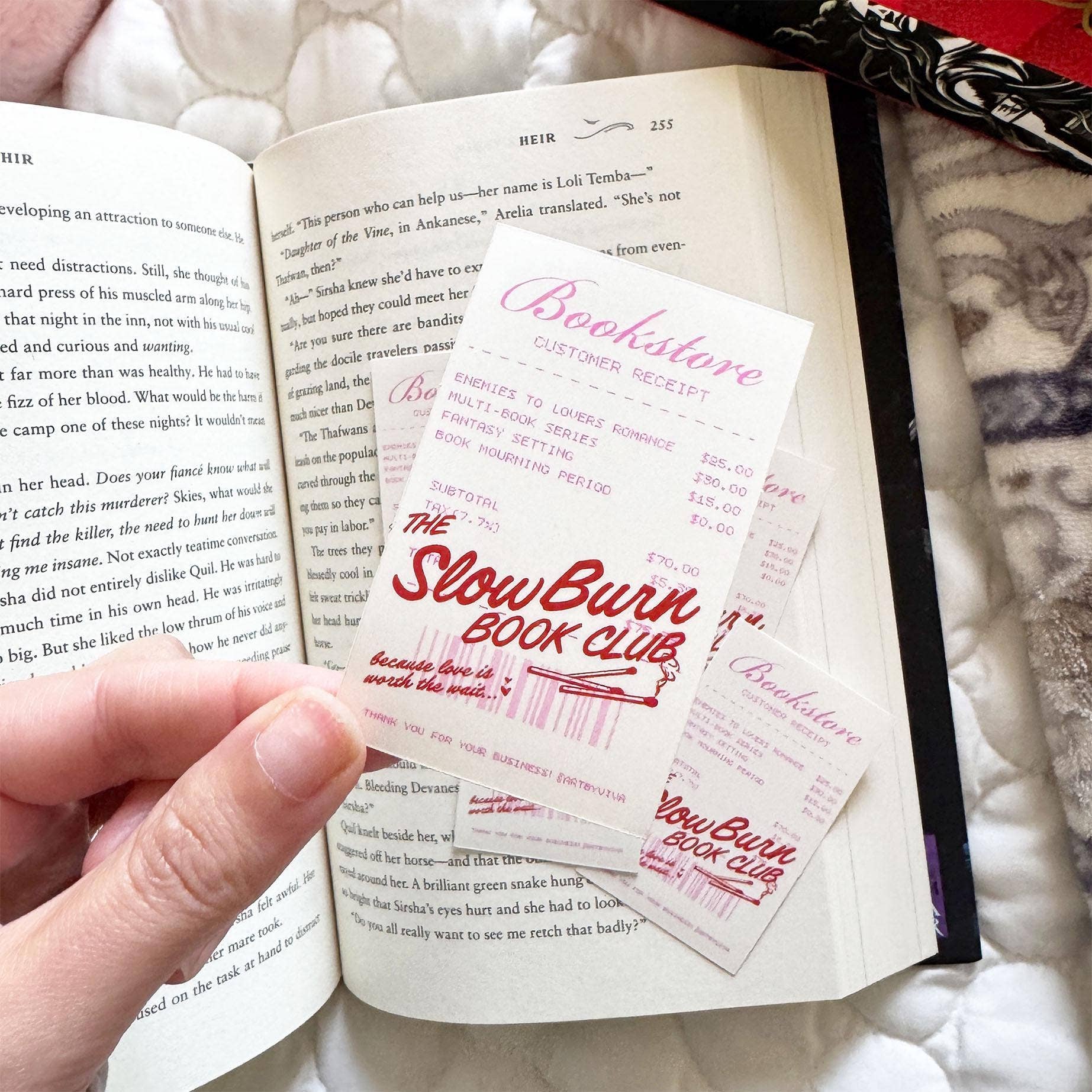 Open book with 'The Slow Burn Book Club' bookmarks inside