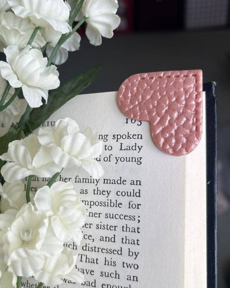 Pink corner bookmark on a book with white flowers around
