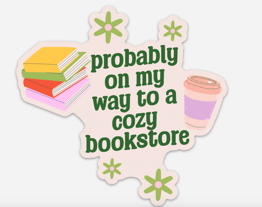 Sticker with books, flowers, and a coffee cup on a light pink background with text 'Probably on my way to a cozy bookstore'.