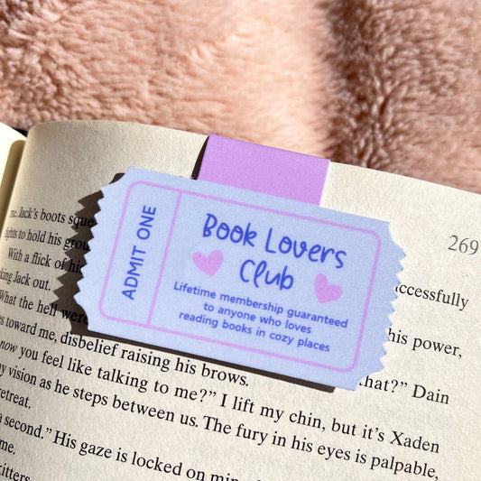 Book lovers club ticket attached to a book with a fluffy pink background