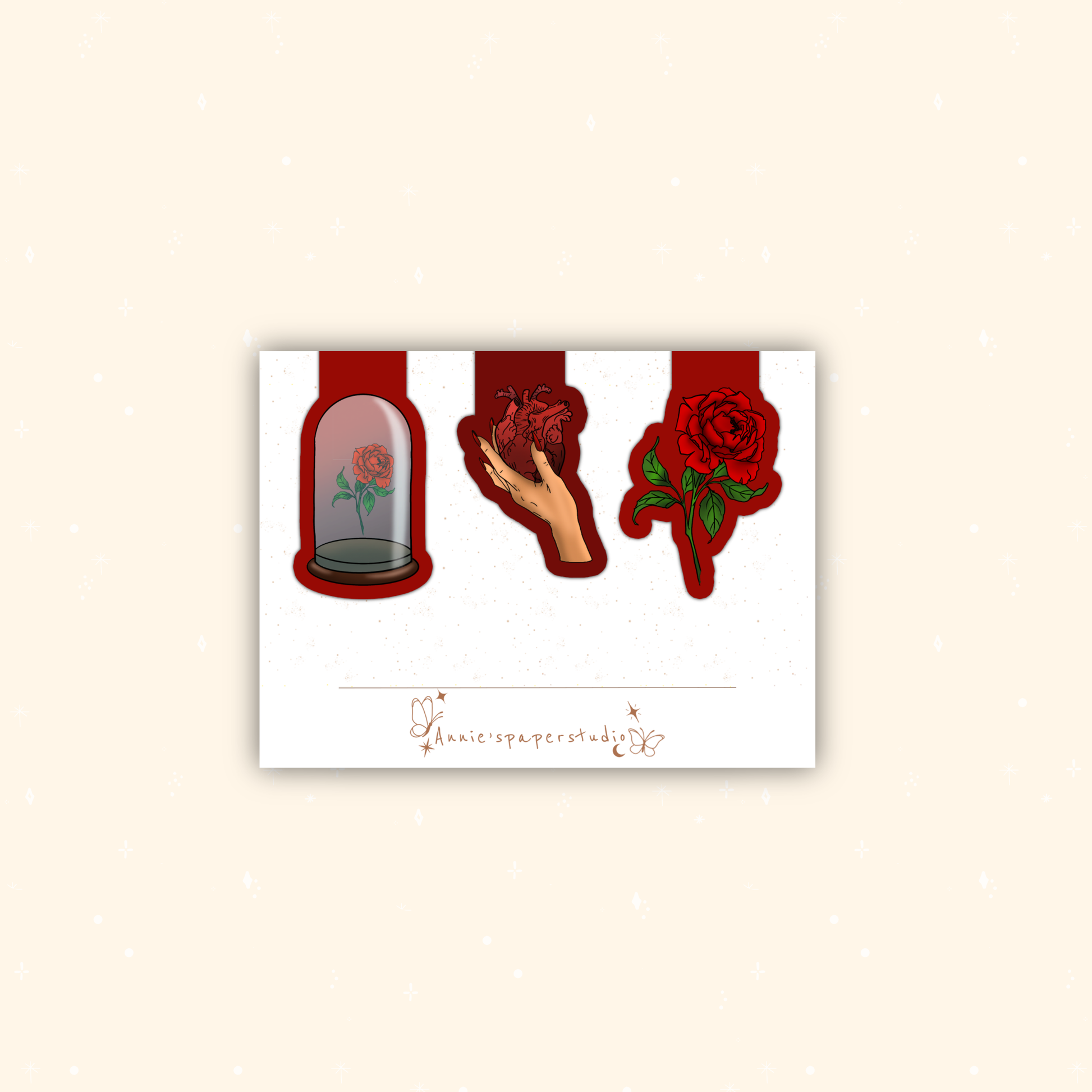A white rectangular art print or card centered on a warm beige background, featuring three red-themed illustrations: a rose under a glass cloche, a hand holding a red heart, and a red rose with green leaves. A small cursive signature is printed near the bottom.